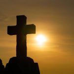 stone cross at sunset